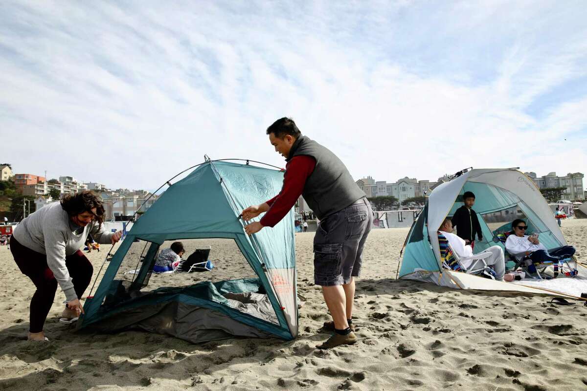 Charlene Rotandi and her husband Edhi Rotandi of San Francisco try to pitch their tent again as strong winds continued to knock it down at Ocean Beach in October.