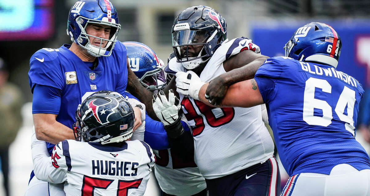 New York Giants quarterback Daniel Jones (8) is sacked by Houston Texans defensive end Jerry Hughes (55) and defensive tackle Maliek Collins (96) during the first quarter of an NFL football game Sunday, Nov. 13, 2022, in East Rutherford, N.J.