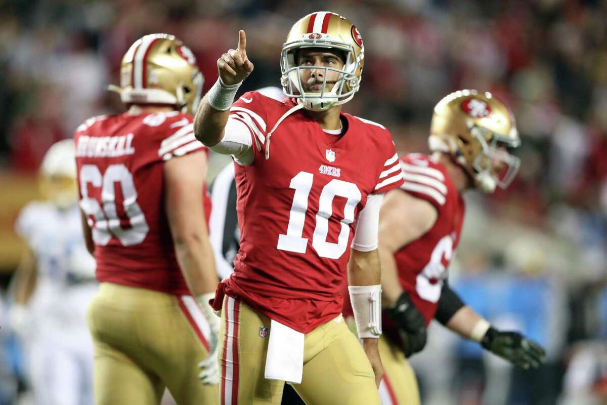 San Francisco quarterback Jimmy Garoppolo points to the stands after scoring on a sneak against the Chargers at Levi’s Stadium. The second-quarter touchdown cut the Los Angeles lead to 13-10.