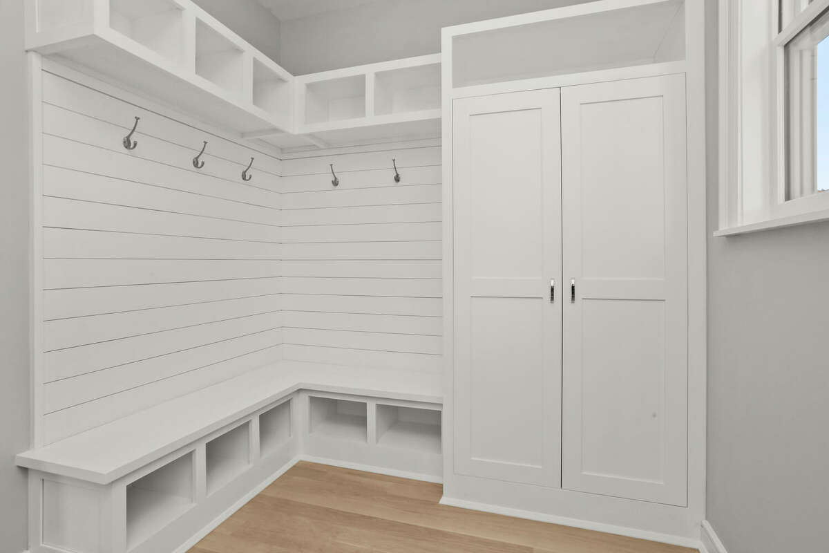 The builder/seller added a convenient mudroom to the floor plan, complete with cubbies, a cabinet, hanging space and bench seating.