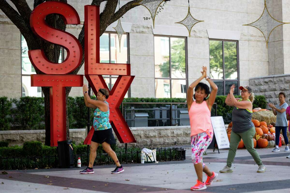 A large “SLTX” sculpture serves as a backdrop for a free weekly Zumba class led by instructor Cida Moore at Sugar Land Town Square on Friday, Nov. 11, 2022.
