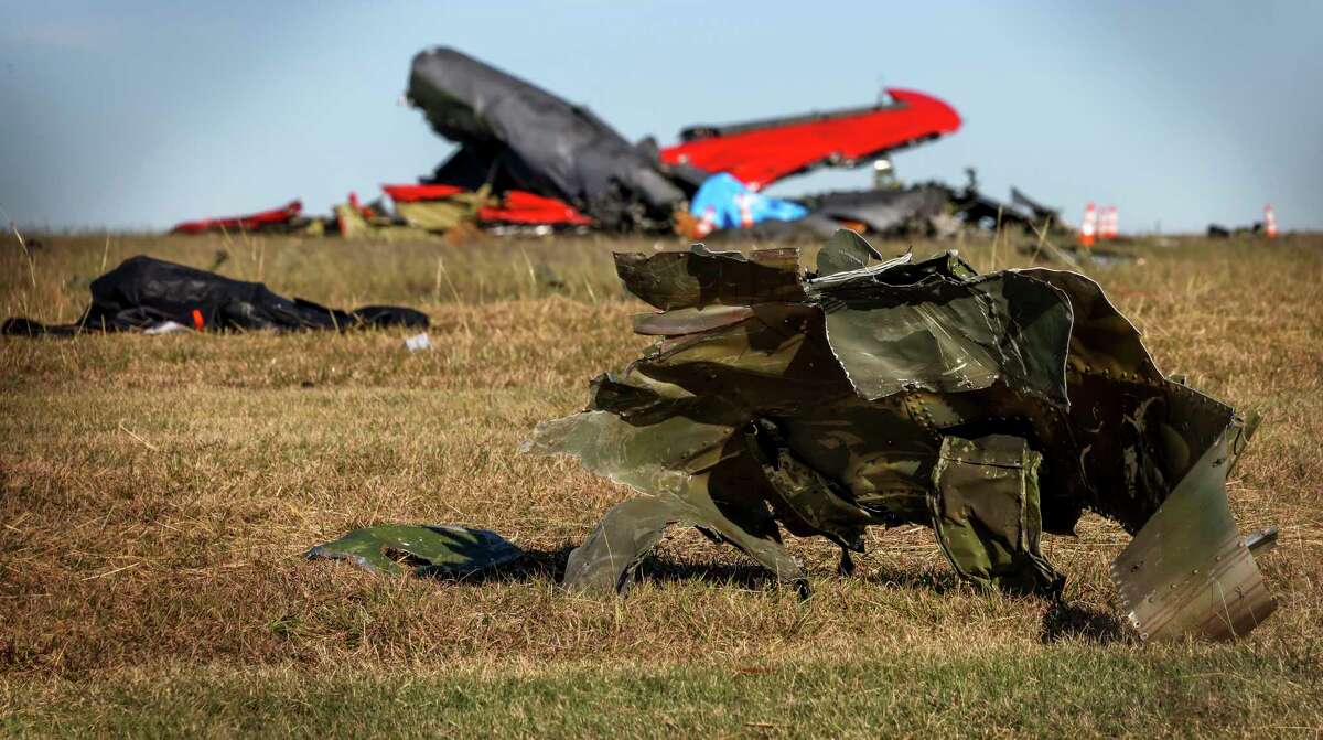 Debris lays across the open field at Dallas Executive Airport on Sunday, Nov. 13, 2022, in Dallas, after a Boeing B-17 Flying Fortress and a Bell P-63 Kingcobra collided and crashed a day earlier. (Liesbeth Powers/The Dallas Morning News via AP)