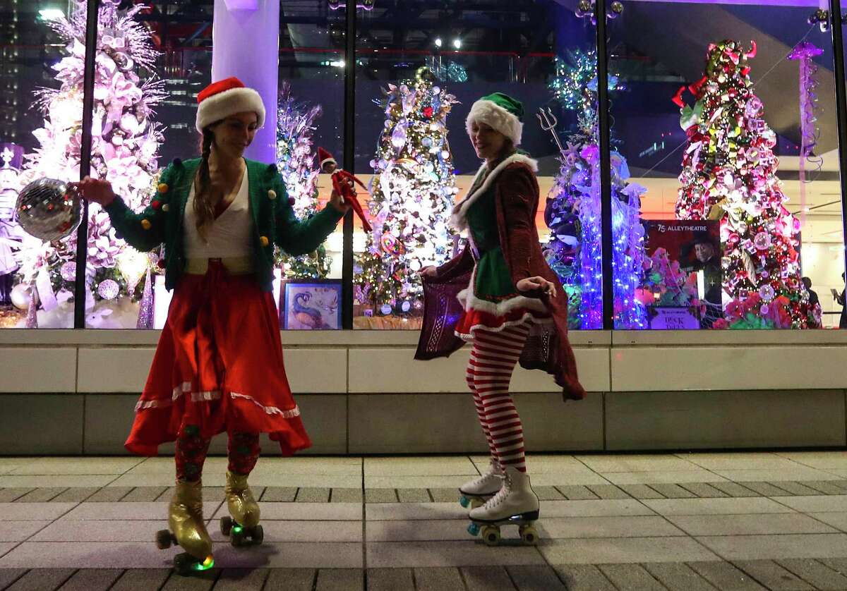 Skaters perform outside of the Christmas tree display during the second annual City Lights at Avenida Houston, between the George R. Brown and Discovery Green, Thursday, Nov. 18, 2021, in Houston.