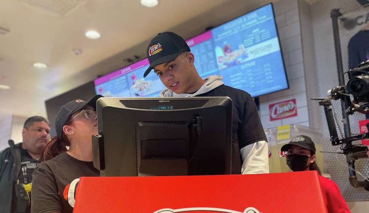 Astros rookie shortstop Jeremy Peña took orders at the Raising Canes along Gulf Freeway Monday afternoon with assistance from employee Mariela Banda.