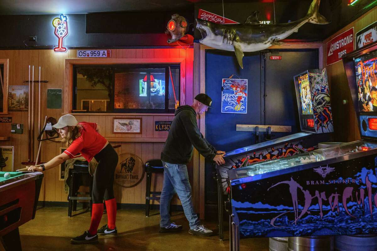 客户打池和使用弹球机在皮特的酒吧。这位50岁的酒吧最近翻修和重新下新的所有权由两个外日落当地人。