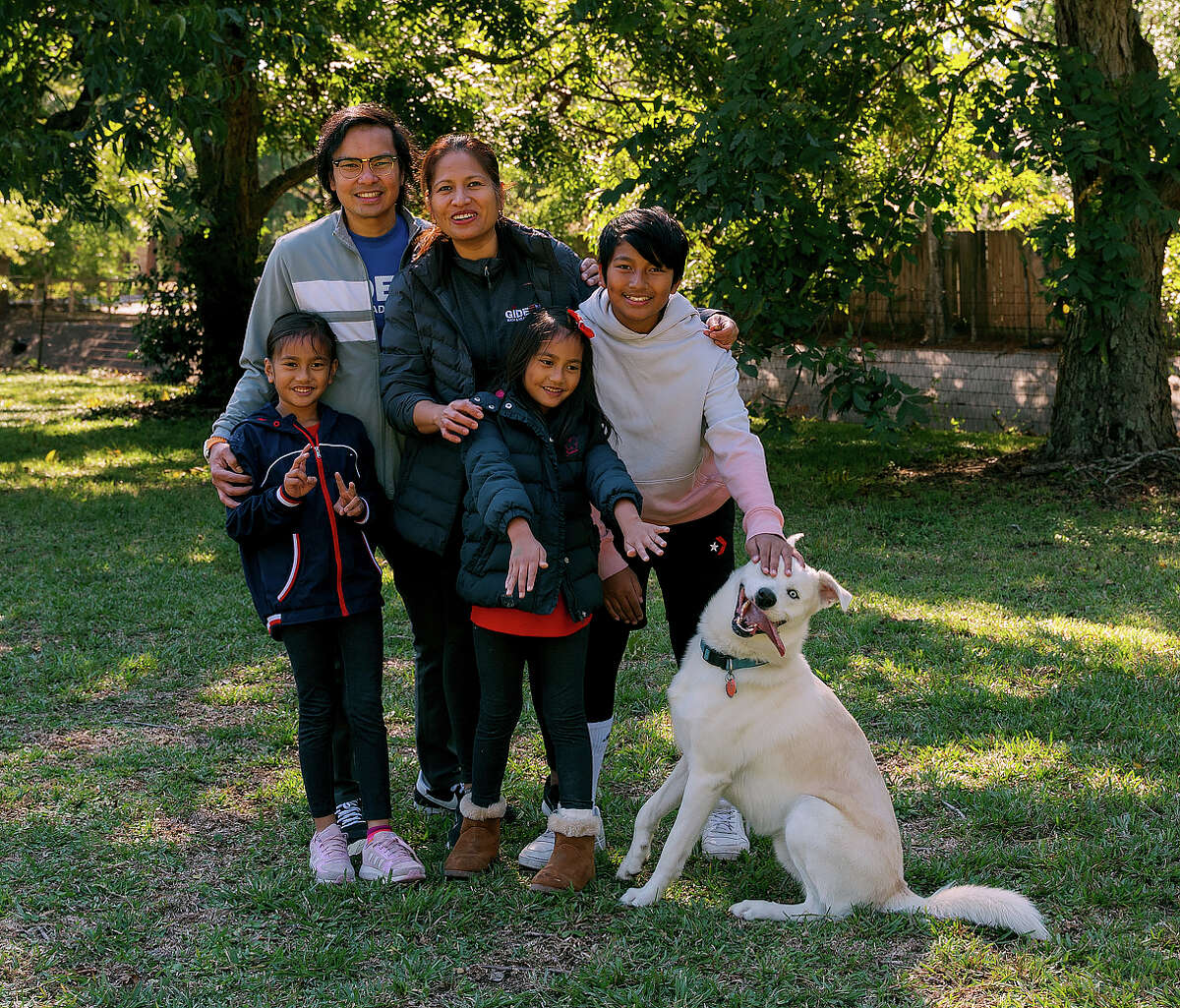 The Reventars poses for a portrait in their yard in Houston, Texas, on Nov. 13, 2022.The Reventars are among the Houston hosts who rent out their yard by the hour for dogs using an app called Sniffspot.