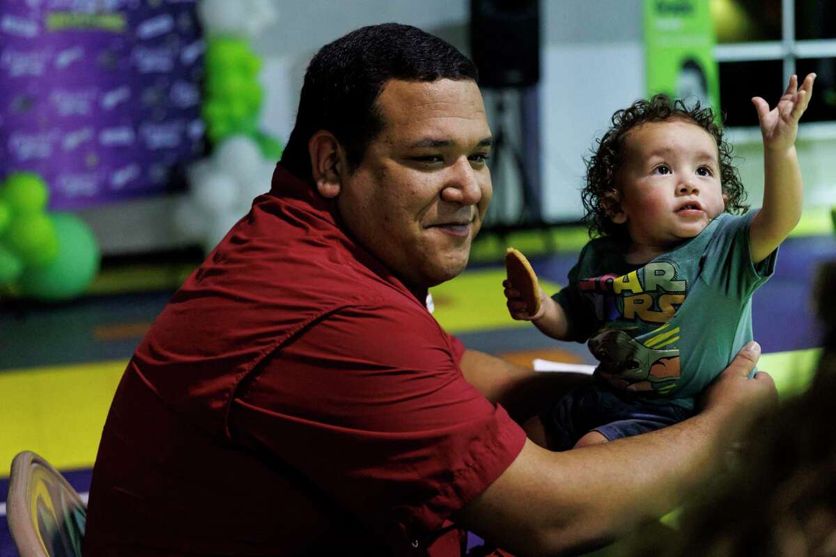 Michael Regino shares a cookie with his 1-year-old son Zachary during the graduation ceremony for fathers enrolled in the Compadre y Compadre program, including Regino, at The Children’s Shelter in San Antonio on Thursday. The 15-week course emphasizes strengthening the male caregiver’s role with their children and family.
