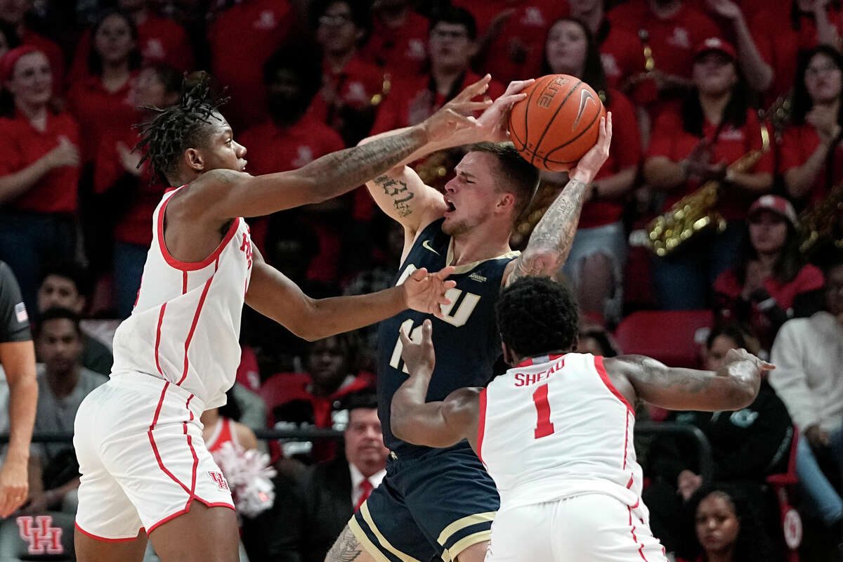 Houston's Jamal Shead (1) and Marcus Sasser, left, pressure Oral Roberts's Carlos Jurgens (11) during the second half of an NCAA college basketball game Monday, Nov. 14, 2022, in Houston. (AP Photo/David J. Phillip)