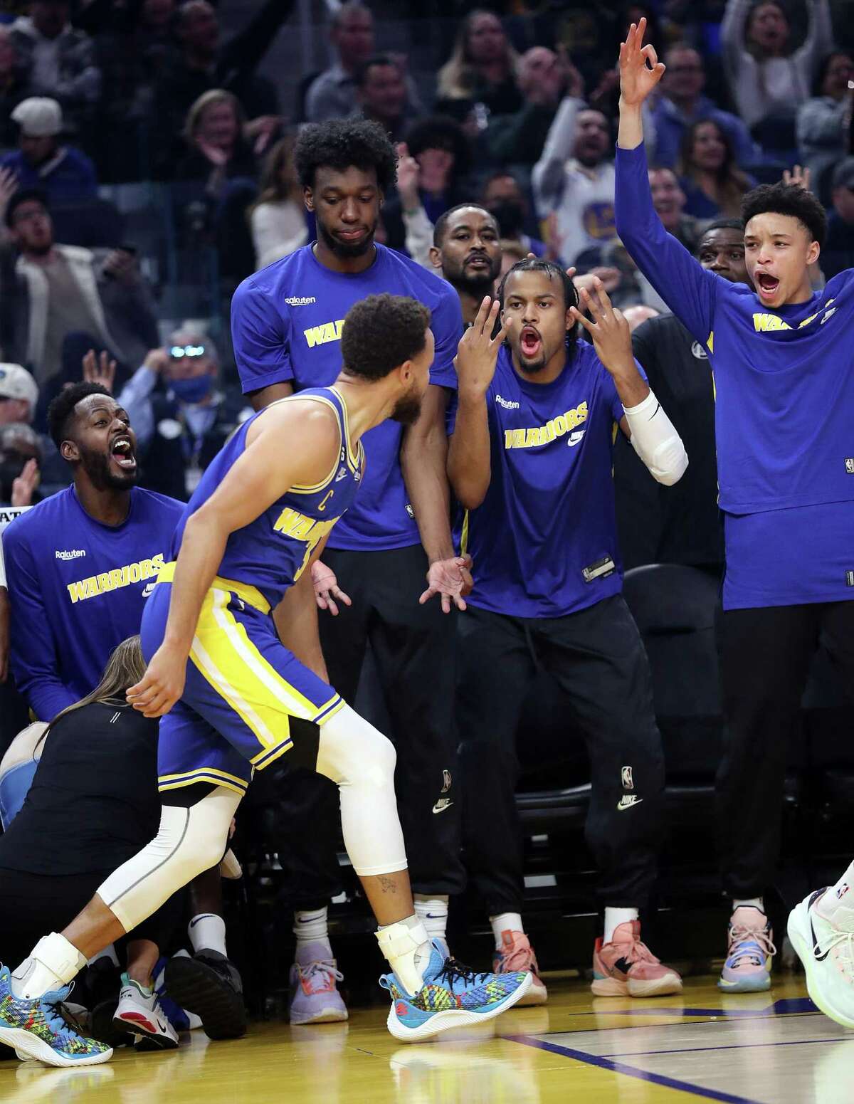 Golden State Warriors’ Moses Moody and Ryan Rollins react to a Stephen Curry 3-pointer in 1st quarter against San Antonio Spurs during NBA game at Chase Center in San Francisco, Calif., on Monday, November 14, 2022.