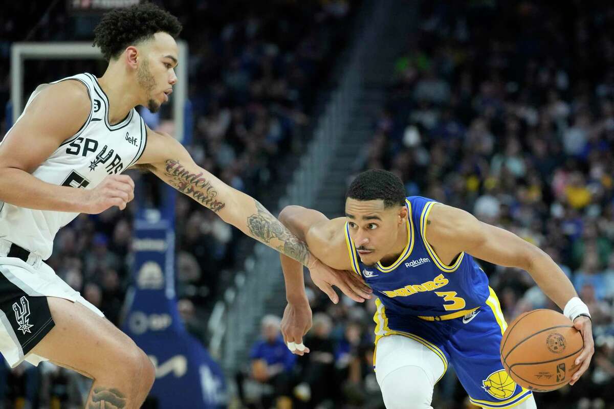 Warriors guard Jordan Poole tries to get around Spurs guard Jordan Hall during the second half of Monday night’s game in San Francisco.