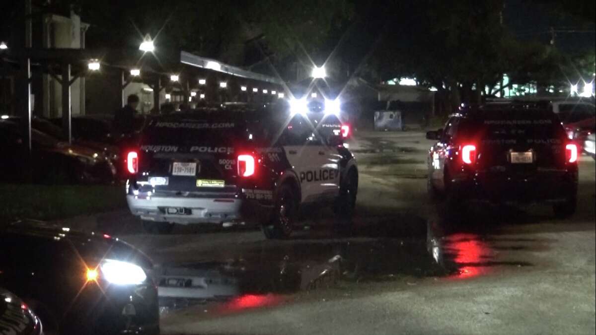 Police cars wait by an apartment complex near Interstate 45 where a shooting happened early Tuesday.