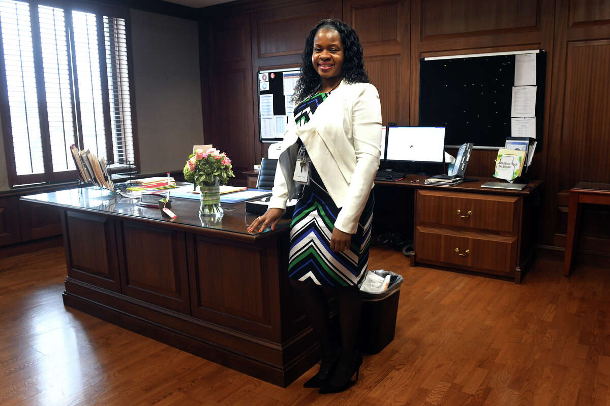 Alyshia Perrin poses next to her desk in the Superintendent of Schools office, in Bridgeport, Conn. Nov. 15, 2022. Perrin has been appointed interim superintendent as the Board of Education searches for someone to fill the position permanently.