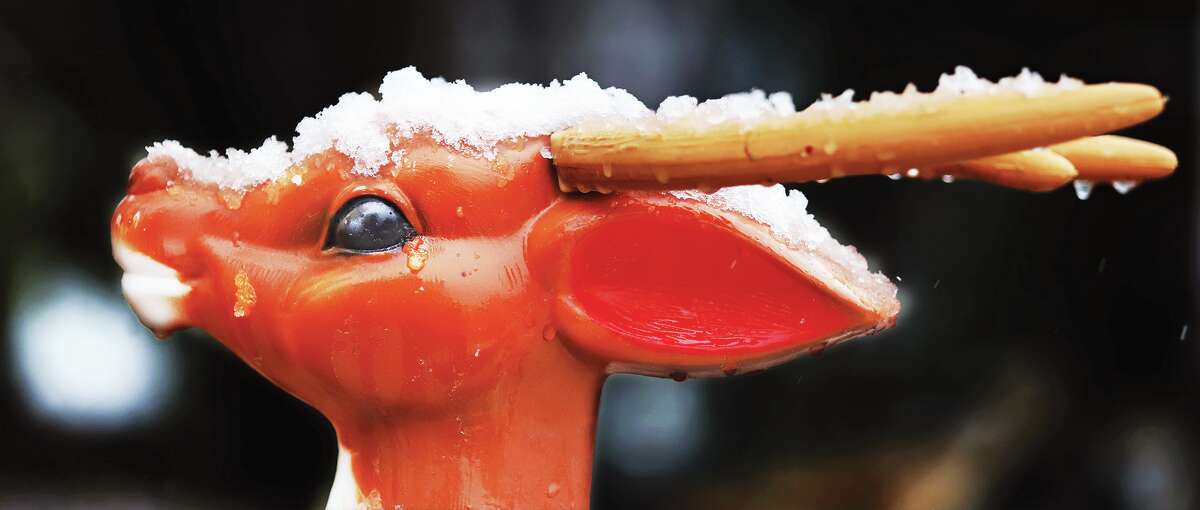 John Badman|The Telegraph Snow tops the heads of Santa's reindeer in the 2000 block of Washington Avenue in Alton following a Tuesday morning dusting.