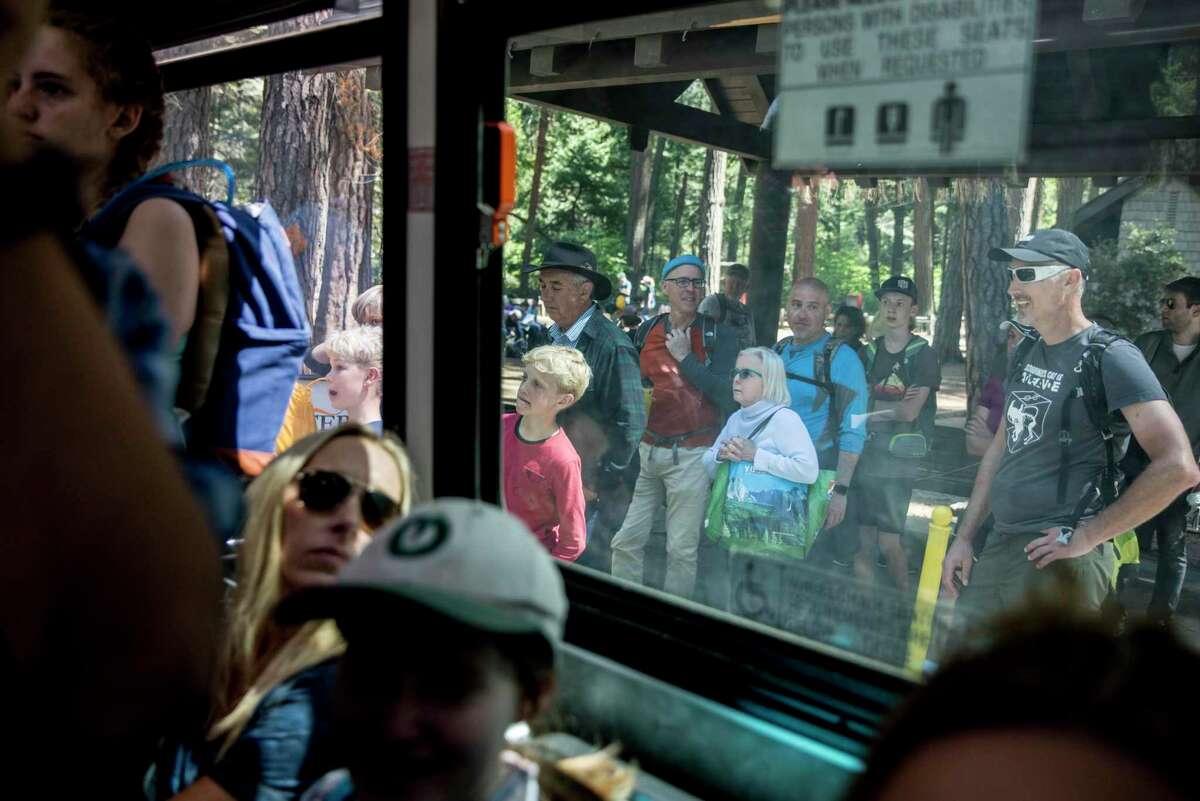 Hikers and tourists line up to board a packed shuttle bus that runs through Yosemite Valley in 2019.