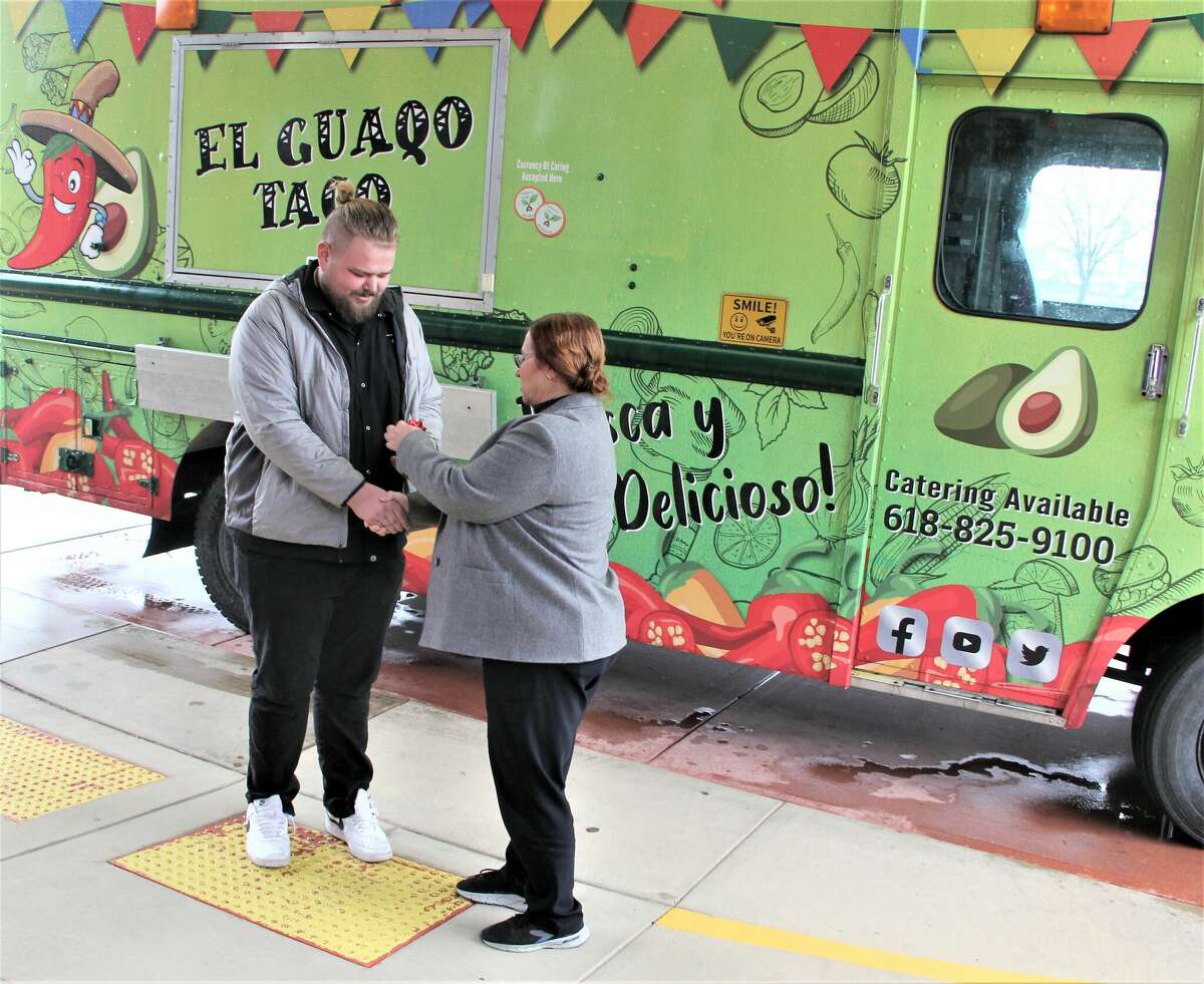 Debra Cremeens-Risinger, Illinois state director for the U.S. Department of Labor/Office of Apprenticeships, hands the keys to a food truck to Peter Bergt, of Belleville, one of the first graduates of a food truck apprenticeship program run by Soulcial Kitchen, a Swansea-based company.
