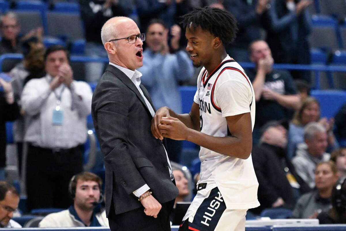 Connecticut head coach Dan Hurley celebrates with Connecticut's Tristen Newton (2) after Newton came out of the with a triple double in the second half of an NCAA college basketball game against Buffalo, Tuesday, Nov. 15, 2022, in Hartford, Conn.