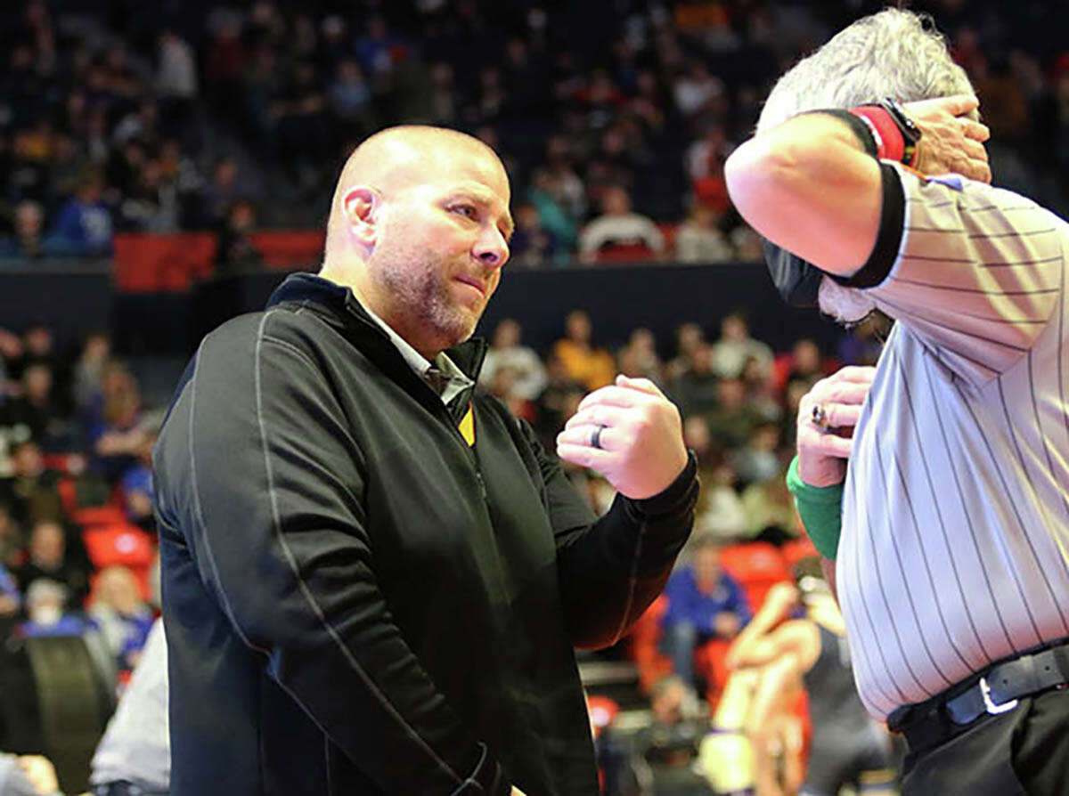 CM coach Jeremy Christeson (left) gets an explanation from an official during an Eagles match as last season's Class 2A state tourney in Champaign.