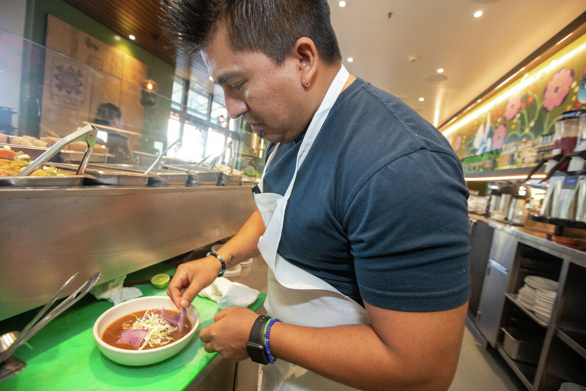 Nopalito chef Gonzalo Guzman plates his pozole dish, on Nov. 15, 2022.