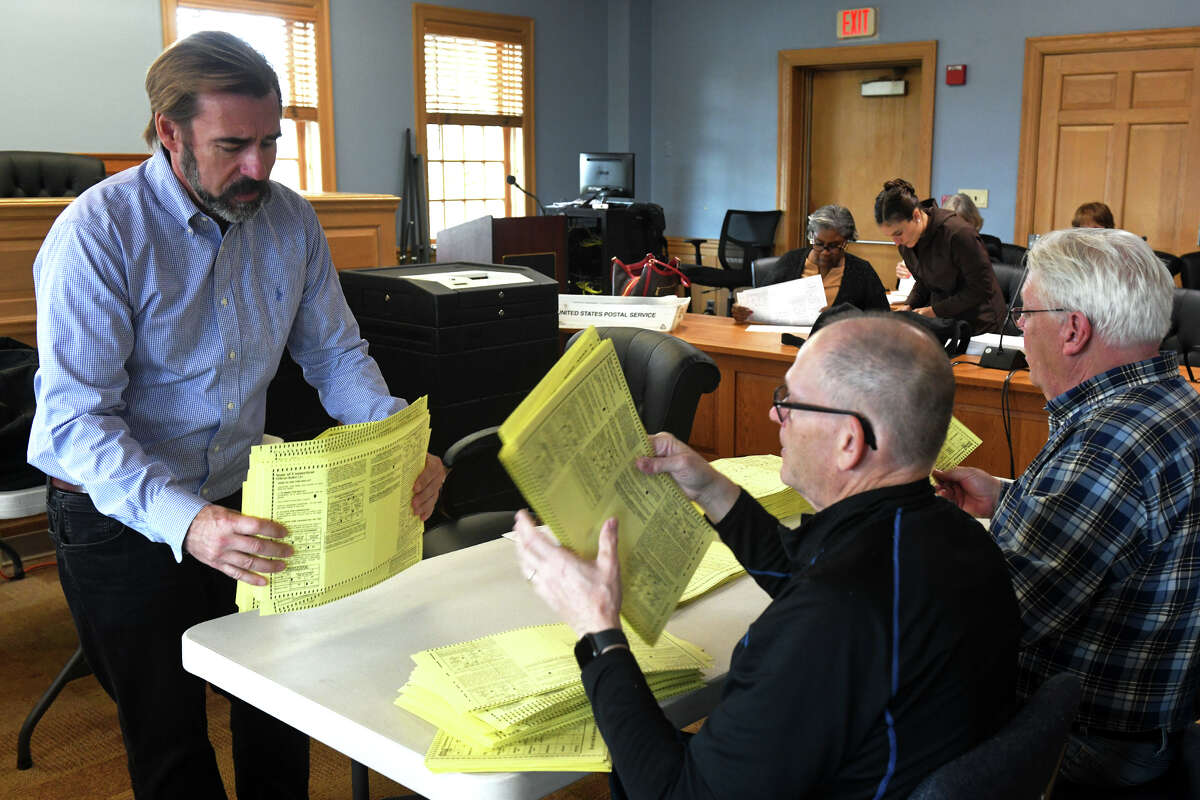 Election officials and volunteers inspect ballots at the start of an election recount for the 134th State House District in Trumbull Town Hall, in Trumbull, Conn. Nov. 16, 2022.