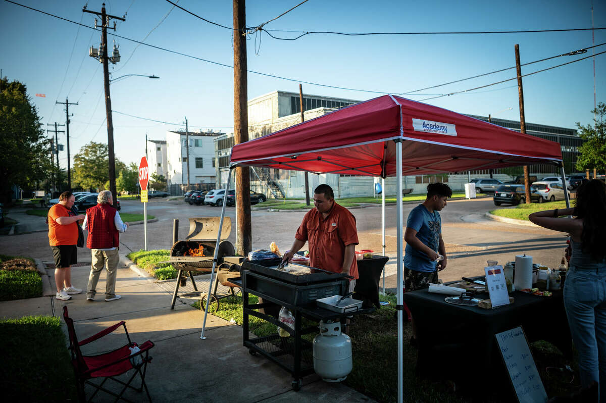 Roger Mejia (center) grills chicken and beef tacos and quesadillas during a block party in the Second Ward on Saturday, November 5, 2022 in Houston, Texas.