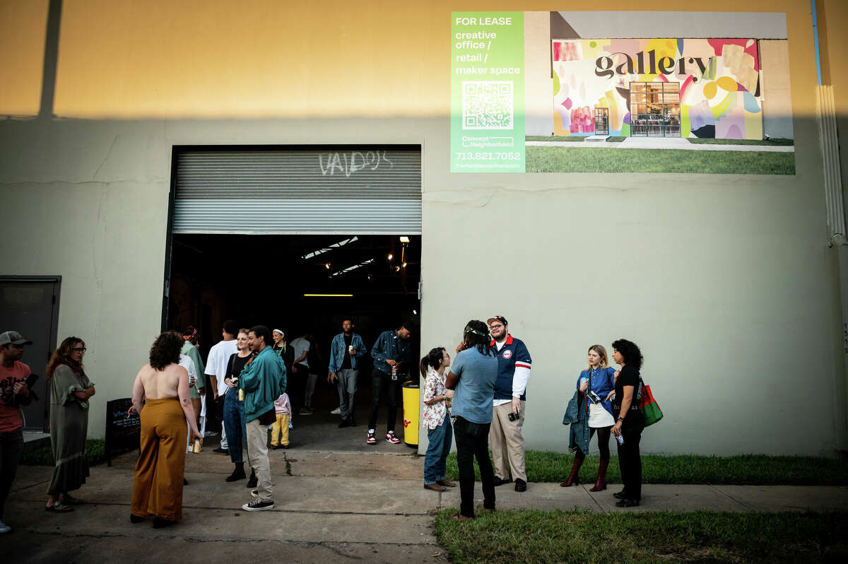 People hang out outside of an old warehouse, owned by Concept Neighborhood during a block party in the Second Ward in Houston, Texas on Saturday, November 5, 2022. Concept Neighborhood plans to rent the property as a creative or retail space, as part of their project to redevelop several blocks in the Second Ward in a socially conscious way that is pedestrian and bike-friendly and uplifts local residents and small businesses. 