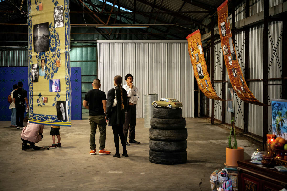 People attend a pop-up art exhibition inside of an old warehouse that is owned by Concept Neighborhood, during a block party in the Second Ward in Houston, Texas on Saturday, November 5, 2022. Concept Neighborhood plans to rent the property as a creative or retail space, as part of their project to redevelop several blocks in the Second Ward in a socially conscious way that is pedestrian and bike-friendly and uplifts local residents and small businesses. 