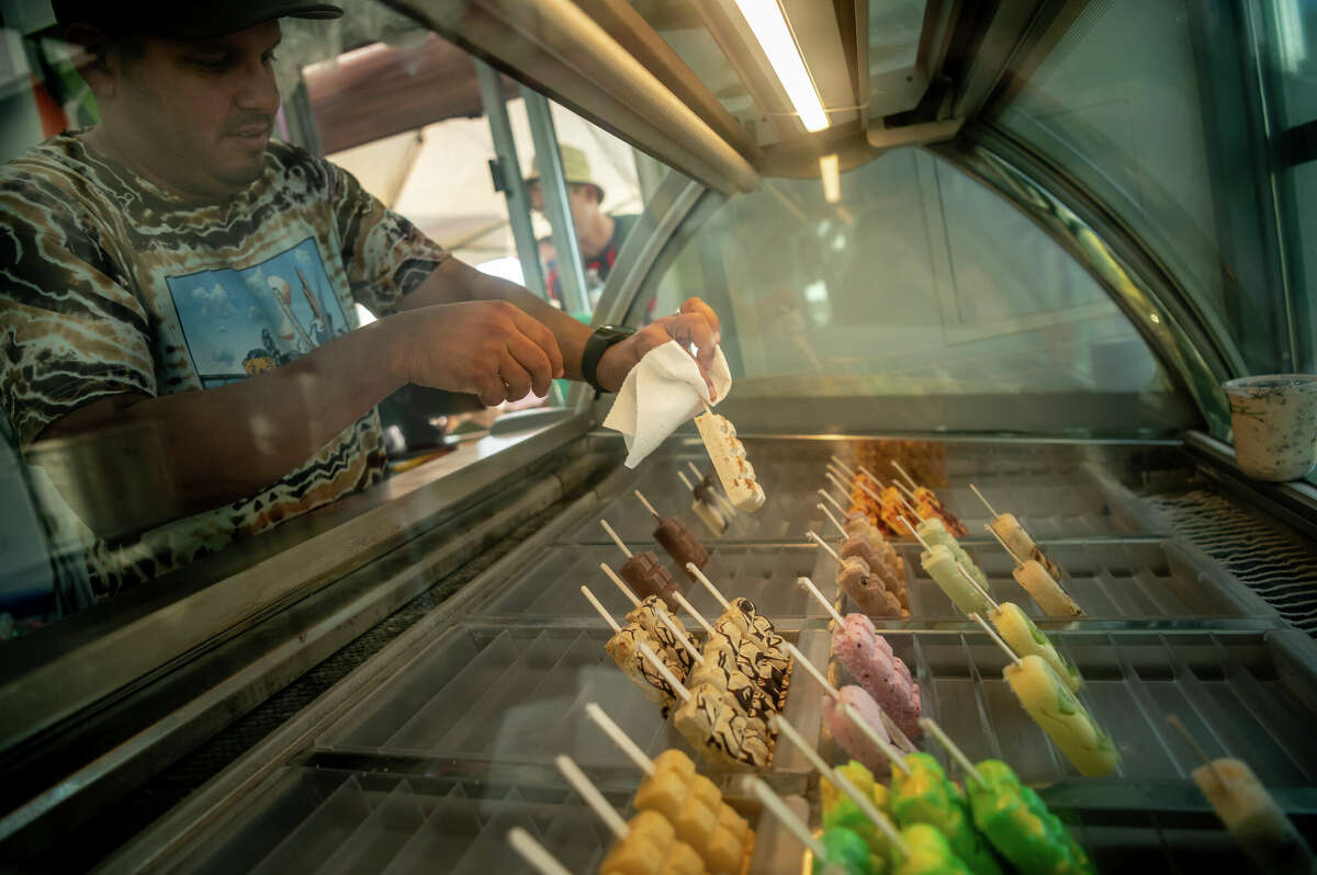 Jonathan Delgado, 39, founder of Popston ice cream shop in the Second Ward, served a steady stream of customers looking for a cool treat during a neighborhood block party on Saturday, November 5, 2022 in Houston, Texas. Delgado's popsicles come in a variety of flavors, from orange honey salted lemonade and pistachio rosewater to fruity pebbles and Buc-ee's beaver nugget salted caramel. 