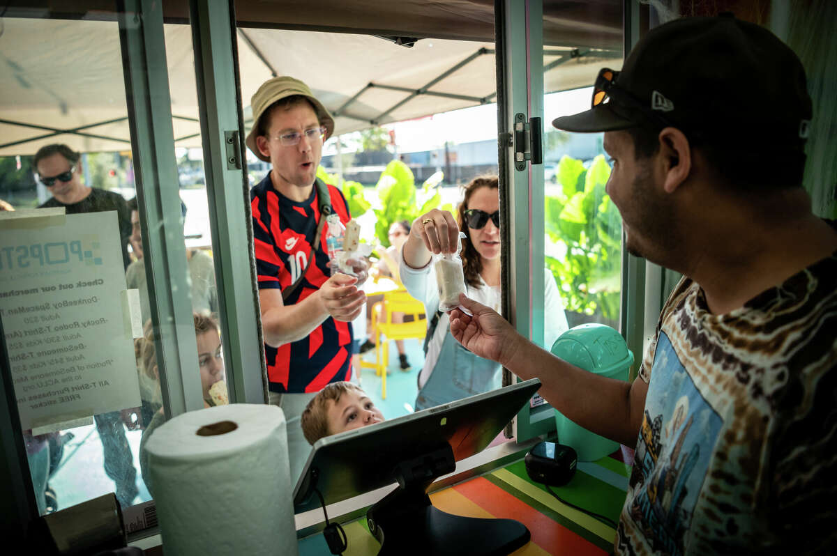 Jonathan Delgado, 39, founder of Popston ice cream shop in the Second Ward, served a steady stream of customers looking for a cool treat during a neighborhood block party on Saturday, November 5, 2022 in Houston, Texas. Delgado's popsicles come in a variety of flavors, from orange honey salted lemonade and pistachio rosewater to fruity pebbles and Buc-ee's beaver nugget salted caramel. 