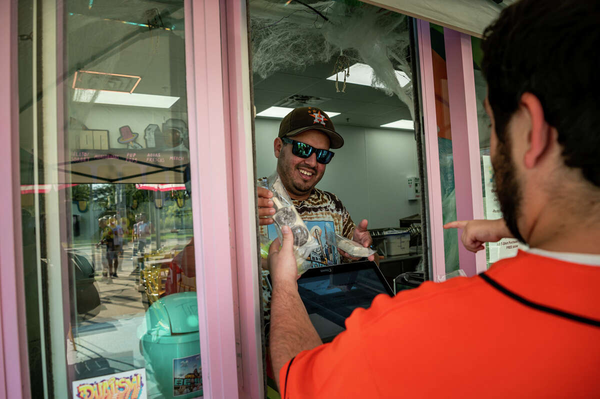 Jonathan Delgado, 39, founder of Popston ice cream shop in the Second Ward, served a steady stream of customers looking for a cool treat during a neighborhood block party on Saturday, November 5, 2022 in Houston, Texas. Delgado's popsicles come in a variety of flavors, from orange honey salted lemonade and pistachio rosewater to fruity pebbles and Buc-ee's beaver nugget salted caramel. 