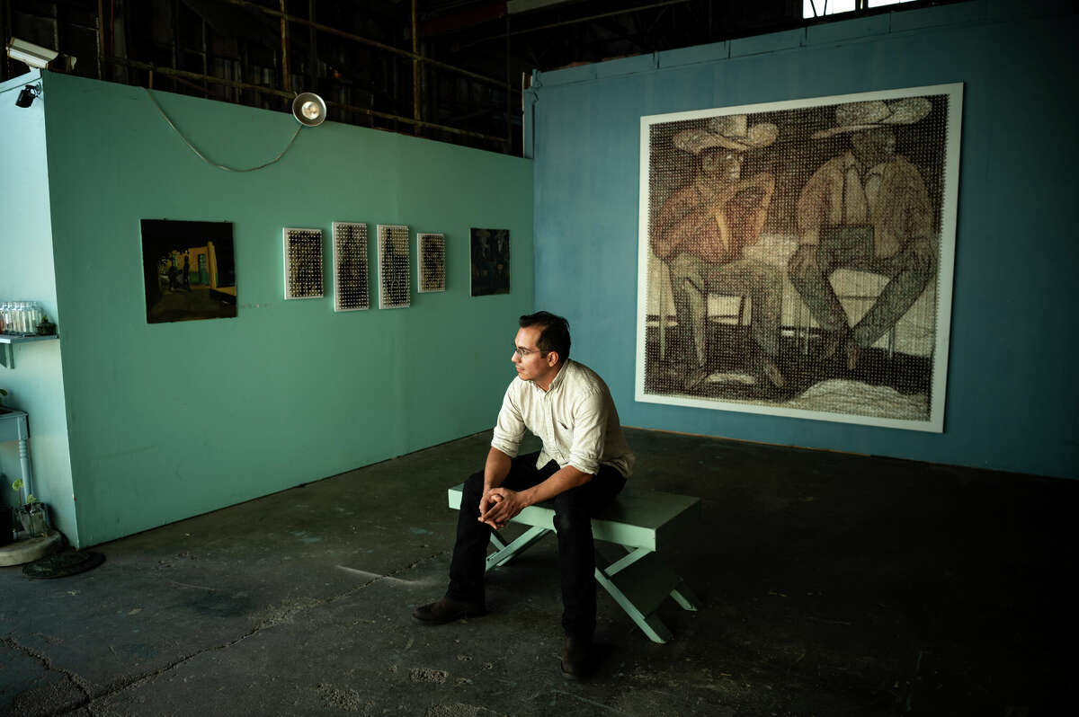 Artist Marcos Hernández Chávez poses for a portrait with his artwork, titled "El baile de los que sobran" made from wool yarn woven on a handmade peg board at El Rincón Studios, an artist's collaborative studio and exhibition venue inside of a converted industrial warehouse in the Second Ward in Houston, Texas during a neighborhood block party on Saturday, November 5, 2022. 