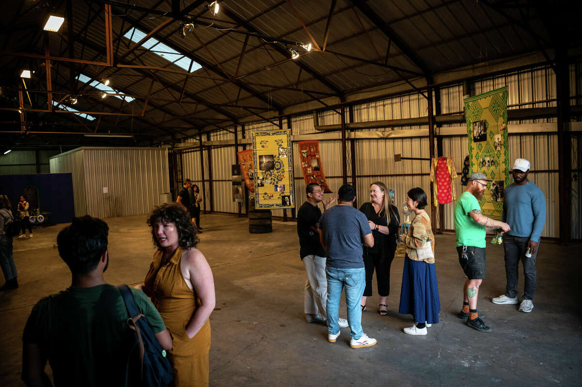 People attend a pop-up art exhibition inside of an old warehouse that is owned by Concept Neighborhood, during a block party in the Second Ward in Houston, Texas on Saturday, November 5, 2022. Concept Neighborhood plans to rent the property as a creative or retail space, as part of their project to redevelop several blocks in the Second Ward in a socially conscious way that is pedestrian and bike-friendly and uplifts local residents and small businesses. 