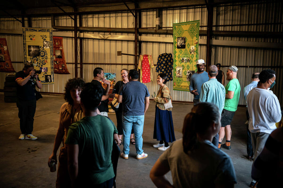 People attend a pop-up art exhibition inside of an old warehouse that is owned by Concept Neighborhood, during a block party in the Second Ward in Houston, Texas on Saturday, November 5, 2022. Concept Neighborhood plans to rent the property as a creative or retail space, as part of their project to redevelop several blocks in the Second Ward in a socially conscious way that is pedestrian and bike-friendly and uplifts local residents and small businesses.