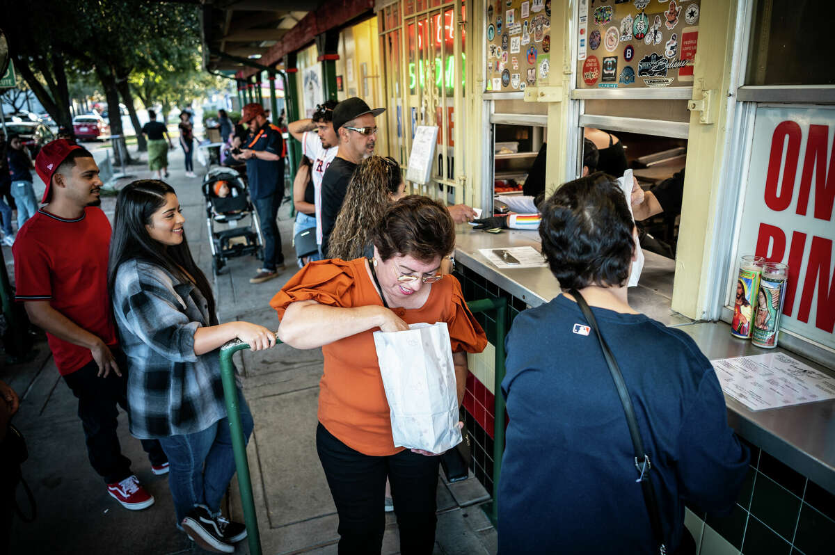 Customers place and pick-up their orders at Champ Burger on Saturday, November 5, 2022 in Houston, Texas. Founded in 1963, it has been a prominent gathering place in the Second Ward for nearly sixty years.