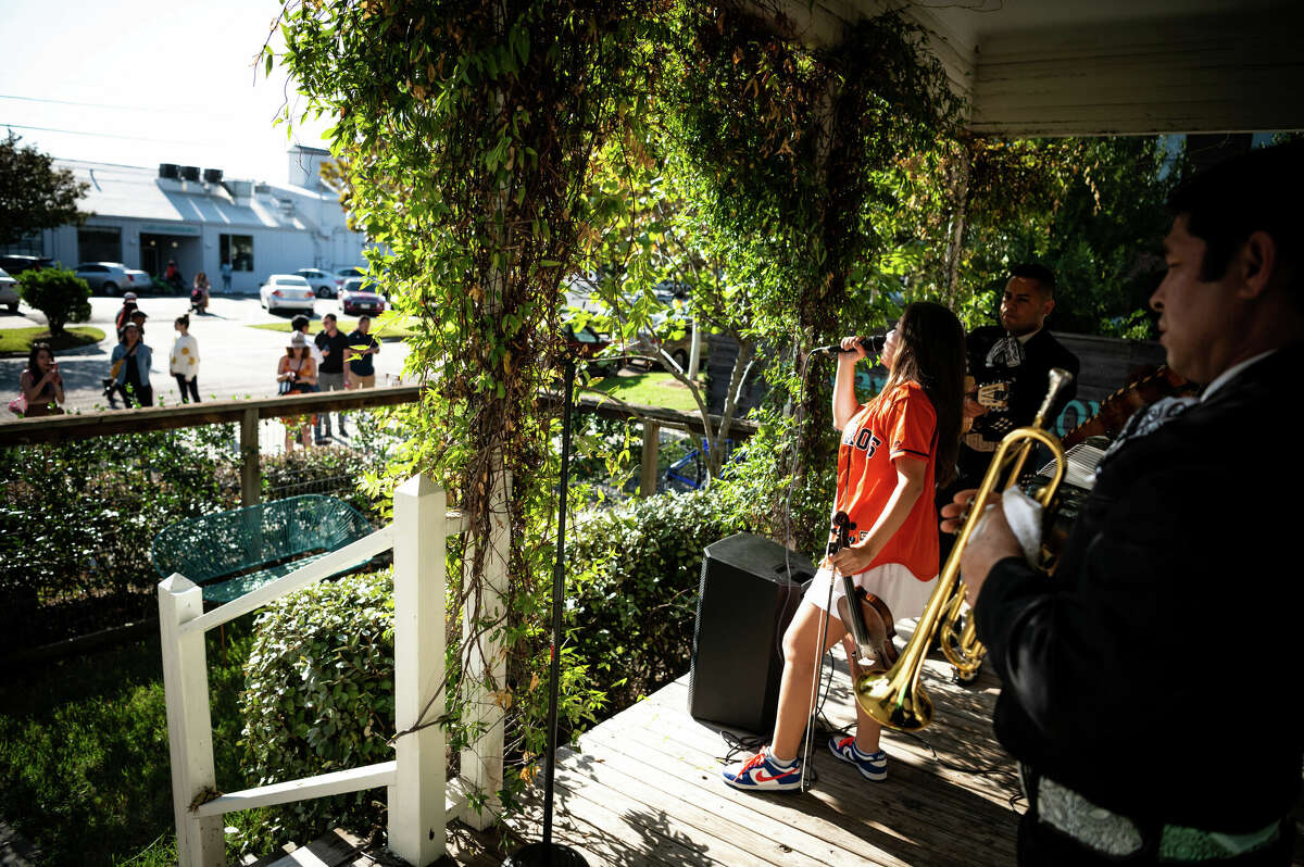 Andrea Daniela performs live music during a block party with her jazziachi band on the front porch of The Plant House, a renovated 1890s house and AirBnB rental in the heart of Concept Neighborhood's development project in the Second Ward, on Saturday, November 5, 2022 in Houston, Texas. She was born and raised in the Second Ward and works as a broker and social media manager at Concept Neighborhood. 