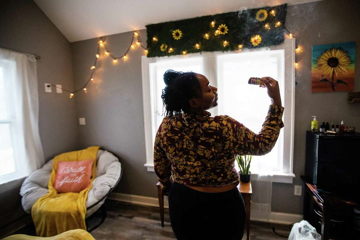 FinessiNBodieS owner Tytiana Arnold lights up sage inside a therapeutic room in her business on the second floor of etc HTX Manor, Sunday, Nov. 13, 2022, in Houston. Arnold is a tantra practitioner and a licensed massage therapist.