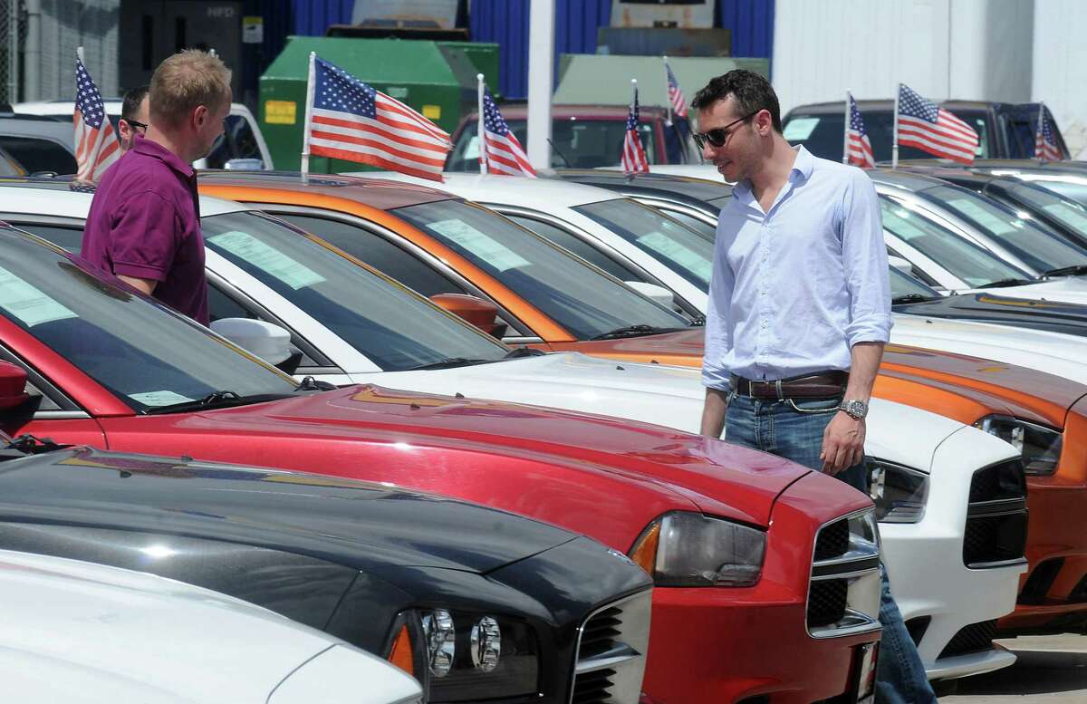 Jovanne Barsano, at right, looks at new Dodge Chargers with the help of his friends at Helfman Dodge on the Katy Freeway Thursday June 19, 2014.(Dave Rossman photo)