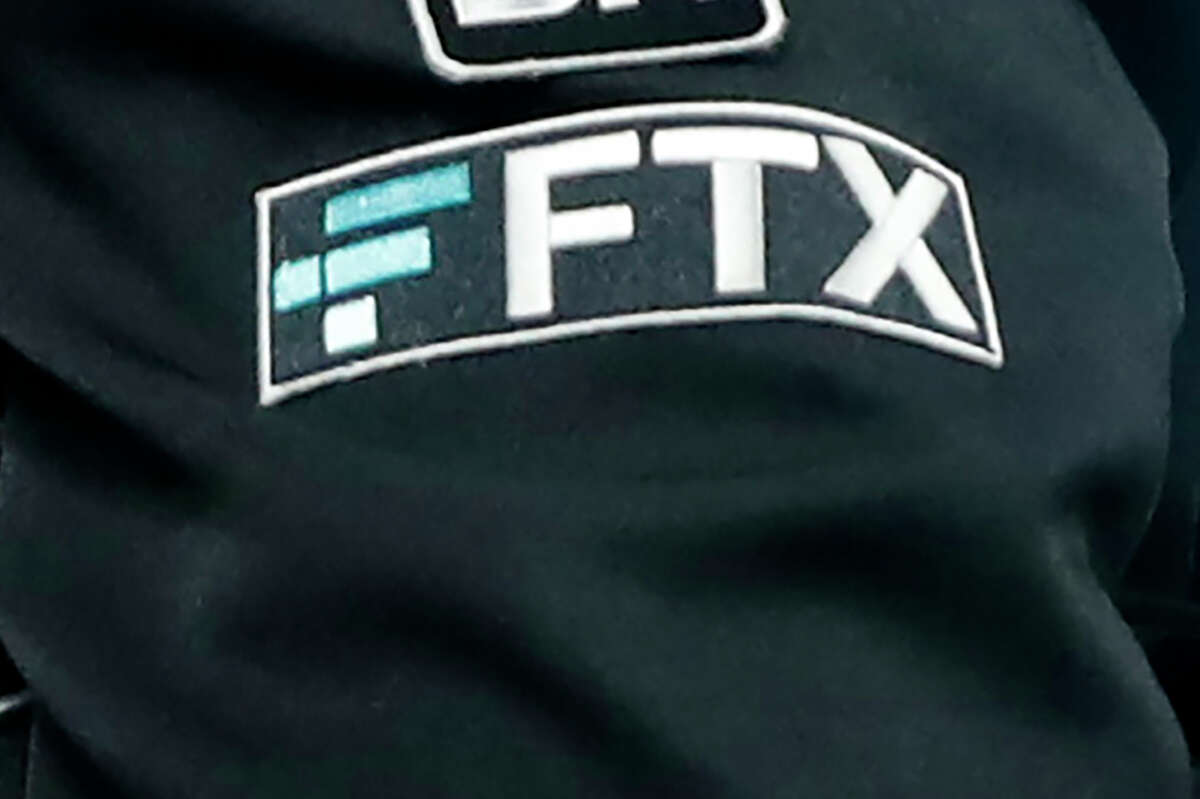 File - The FTX logo appears on home plate umpire Jansen Visconti's jacket at a baseball game with the Minnesota Twins on Tuesday, Sept. 27, 2022, in Minneapolis. The new CEO of the collapse cryptocurrency trading firm FTX, who oversaw Enron’s bankruptcy, said, Thursday, Nov. 17, he has never seen such a “complete failure” of corporate control. John Ray III, in a filing with the U.S. bankruptcy court for the district of Delaware, said there was a “complete absence of trustworthy financial information.”
