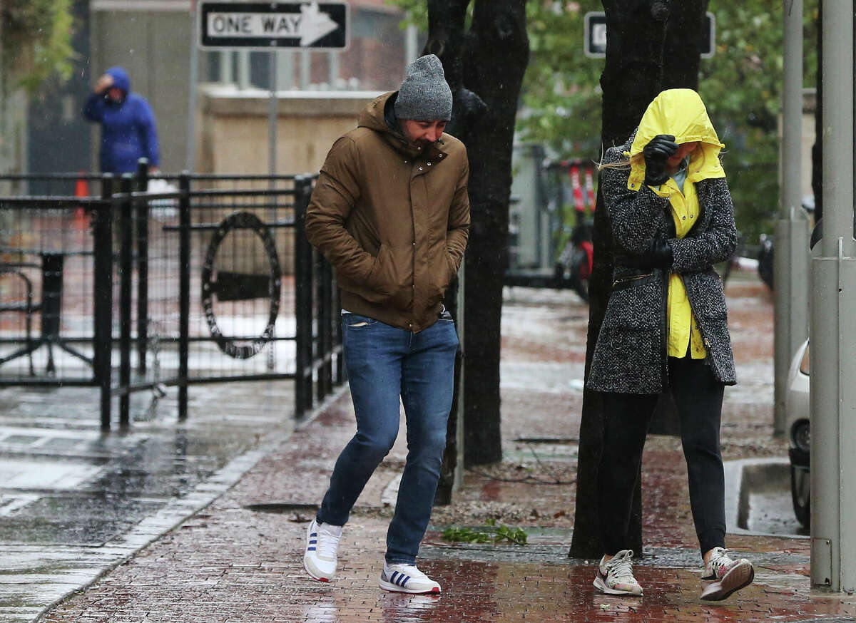 A couple endures the cold and rain while walking downtown on Thursday, Feb. 11, 2021. An incoming cold front is expected to keep the temperatures in the 40s on Saturday with the possibility of rain.