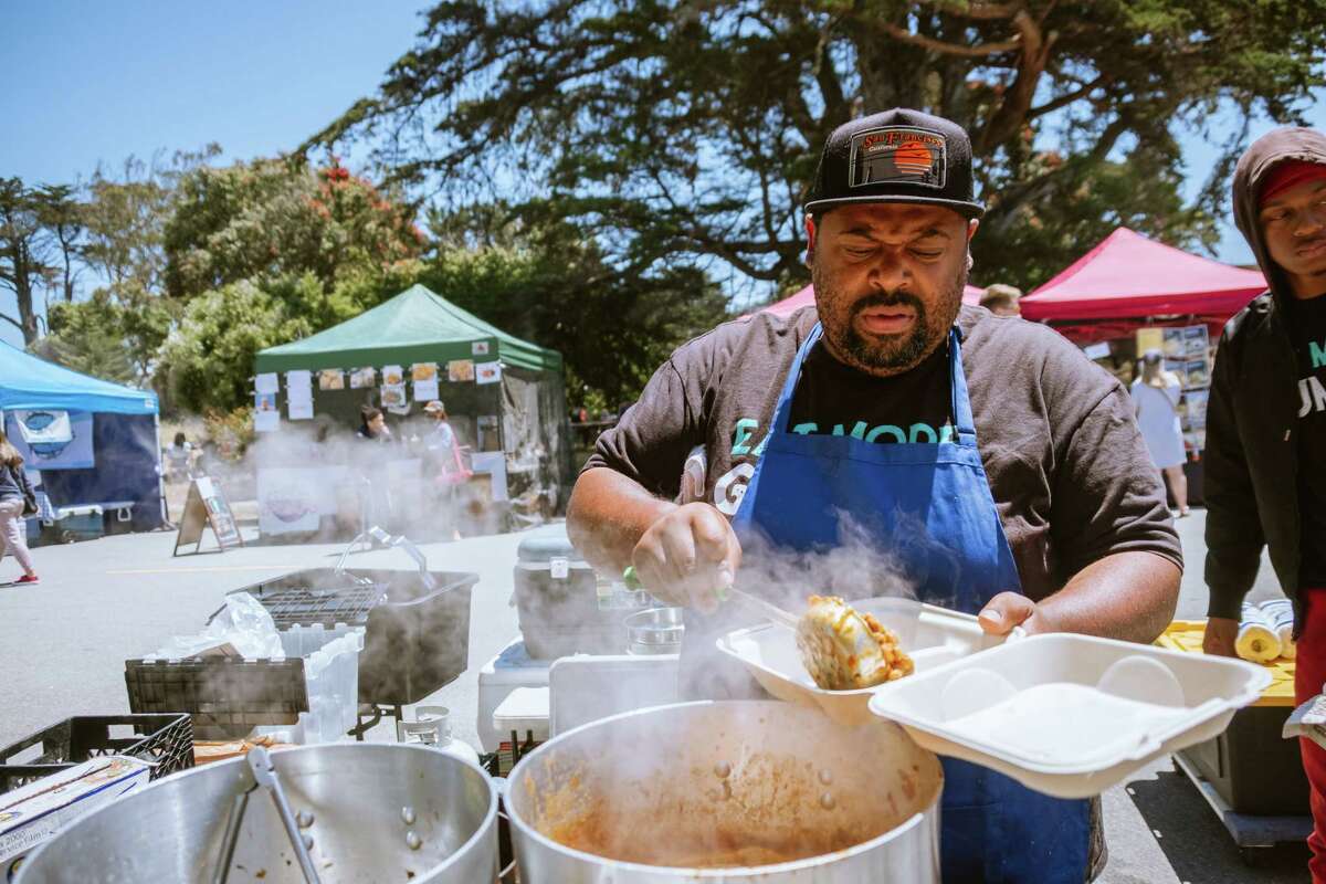 Dontaye Ball, owner of Gumbo Social, makes a plate at the Outer Sunset Farmers Market & Mercantile in San Francisco.