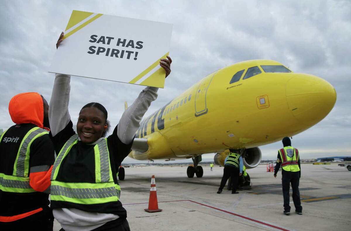 Ramp Agent Chantel Murray holds up a sign as a Spirit Airlines’ Airbus A320 arrives at San Antonio International Airport as officials celebrate the return of the carrier to San Antonio and marks Spirit’s first flight to Orlando on Thursday, Nov. 17, 2022. Spirit Airlines officials also announced routes to Las Vegas, Fort Lauderdale and Baltimore at the event.