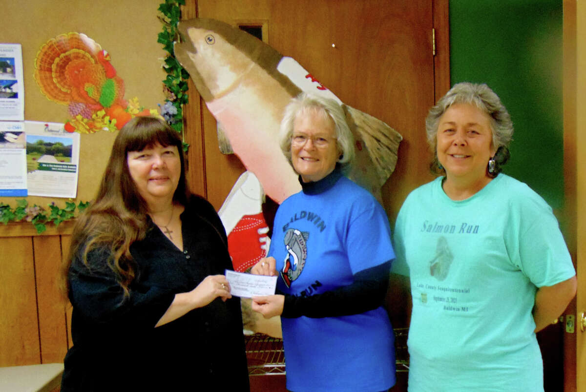 St. Ann Senior Center Director Shelly Shafer accepts a donation for the senior center from Salmon Run Organizers Deborah Hanes and Renee Bernardi. 