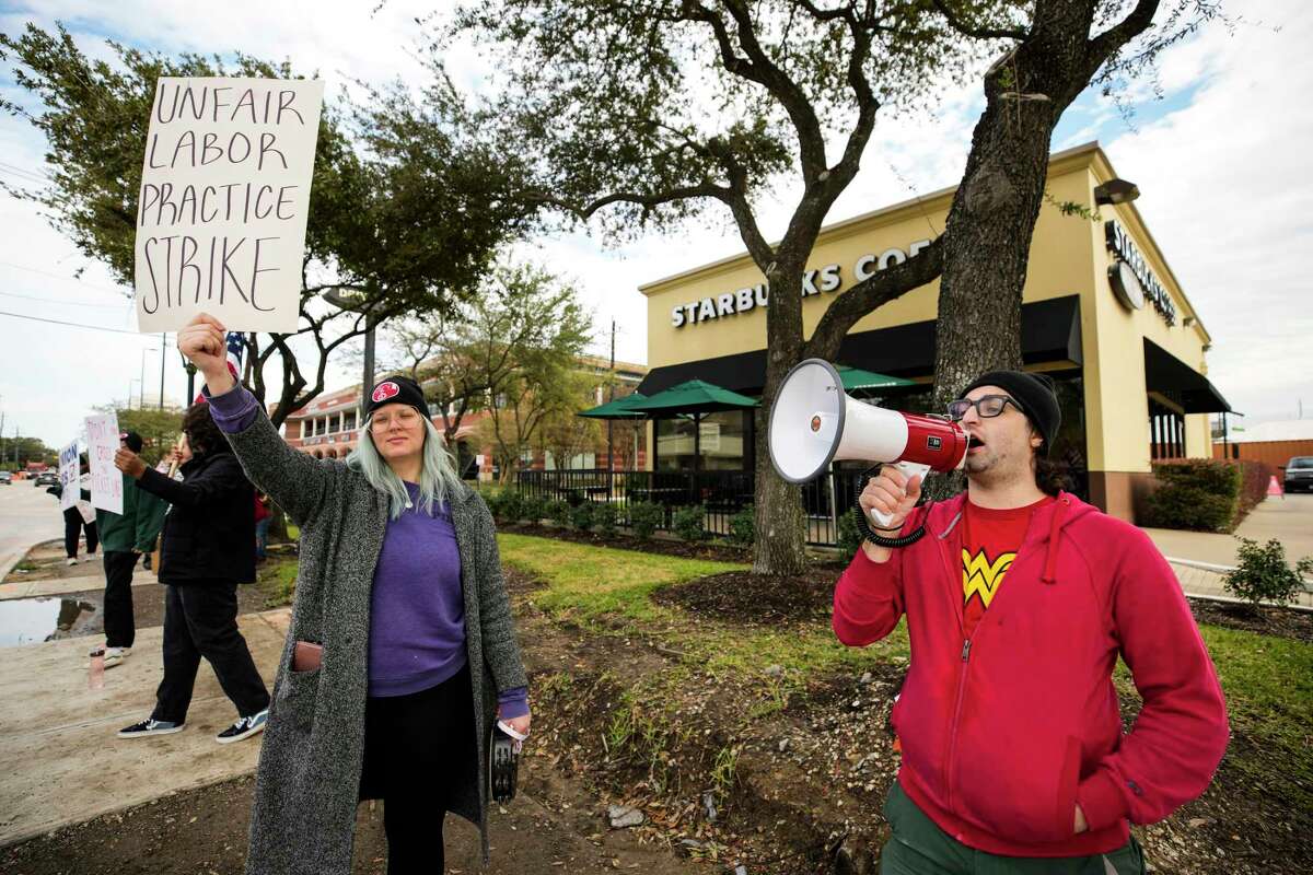 Cameron Davis, right, a former Starbucks employee, leads a demonstration while picketing unfair labor practices outside the Starbucks location in the 1200 block of Shepherd on Thursday, Nov. 17, 2022 in Houston. Starbucks workers are on strike for Red Cup Day, the day where anyone gets a free red cup.