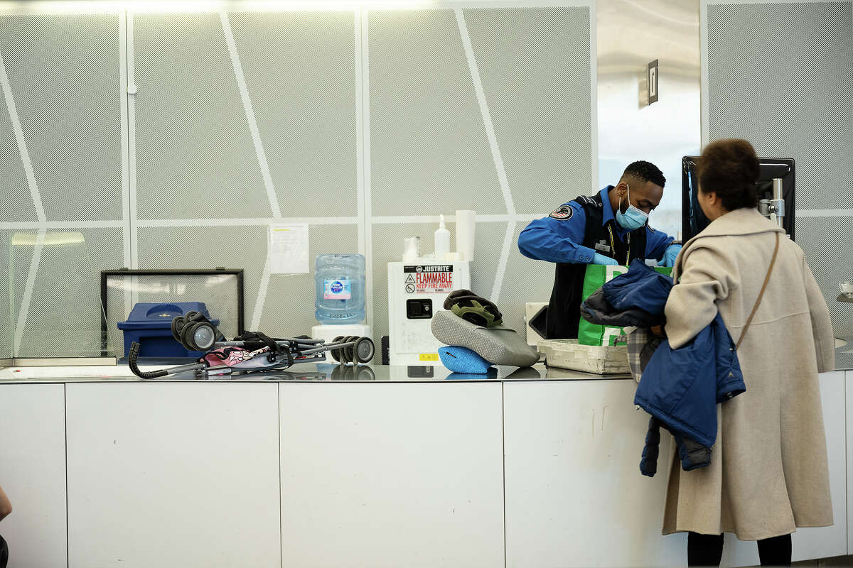 An SFO officer checks carry-on baggage at SFO in San Francisco, California on November 16, 2022.