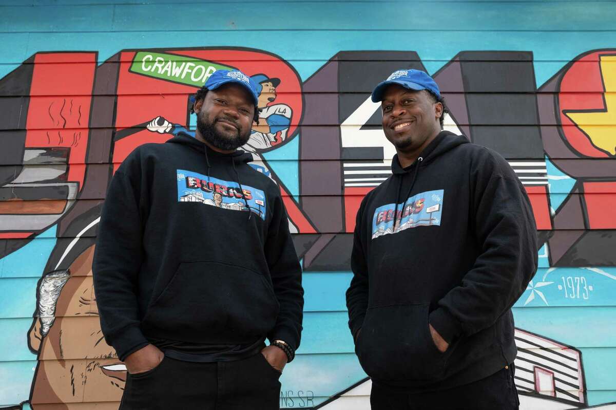 Marcus Carter, operations manager and Corey Crawford, owner of Burns BBQ stand in front of a mural that features Roy Burns Sr., who sold barbecue by the side of the road in Acres Homes,TX which made Burns BBQ a neighborhood institution. Tuesday, Nov. 15, 2022, in Houston.