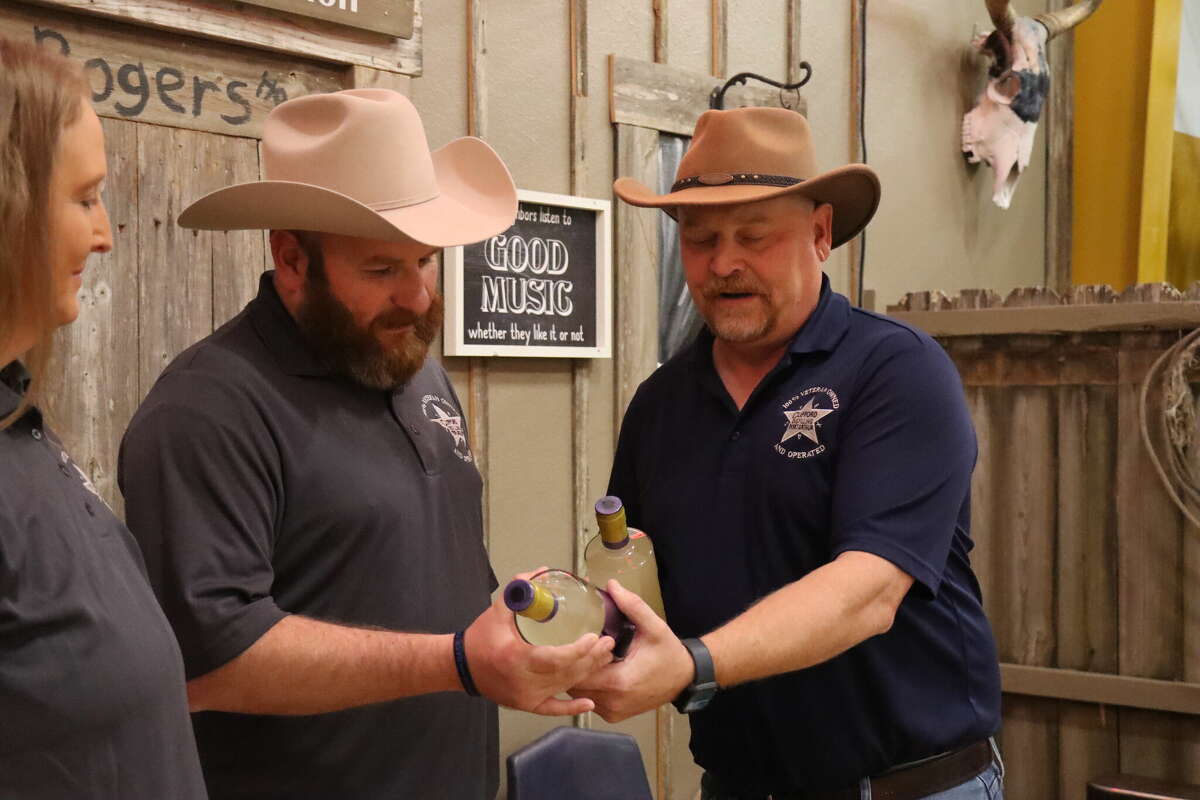 Sean Clifford, owner of Clifford Distilling, gives out autographed bottles of his new gin, called "The Port Arthur," on Thursday, Nov. 17, 2022.