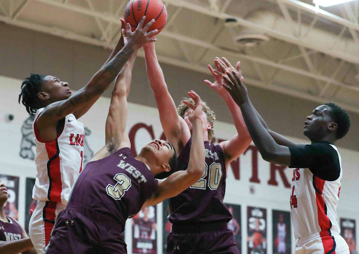 Magnolia West guard Greyson Morgan (3) and power forward Debreon Thompson (20) battle Alief Taylor small forward Clarence Knox (2) for a rebound in the first quarter of a high school basketball game during the Doghouse Invitational at Magnolia High School, Thursday, Nov. 17, 2022, in Magnolia.