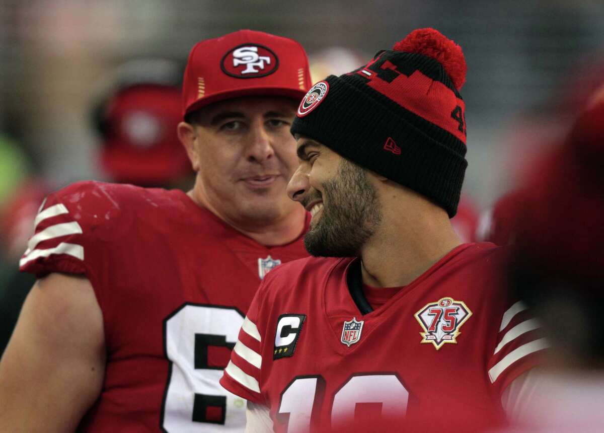 Jimmy Garoppolo (10) smiles with Daniel Brunskill (60) on the sidelines late in the second half as the San Francisco 49ers played the Atlanta Falcons at Levi’s Stadium in Santa Clara, Calif., on Sunday, December 19, 2021.