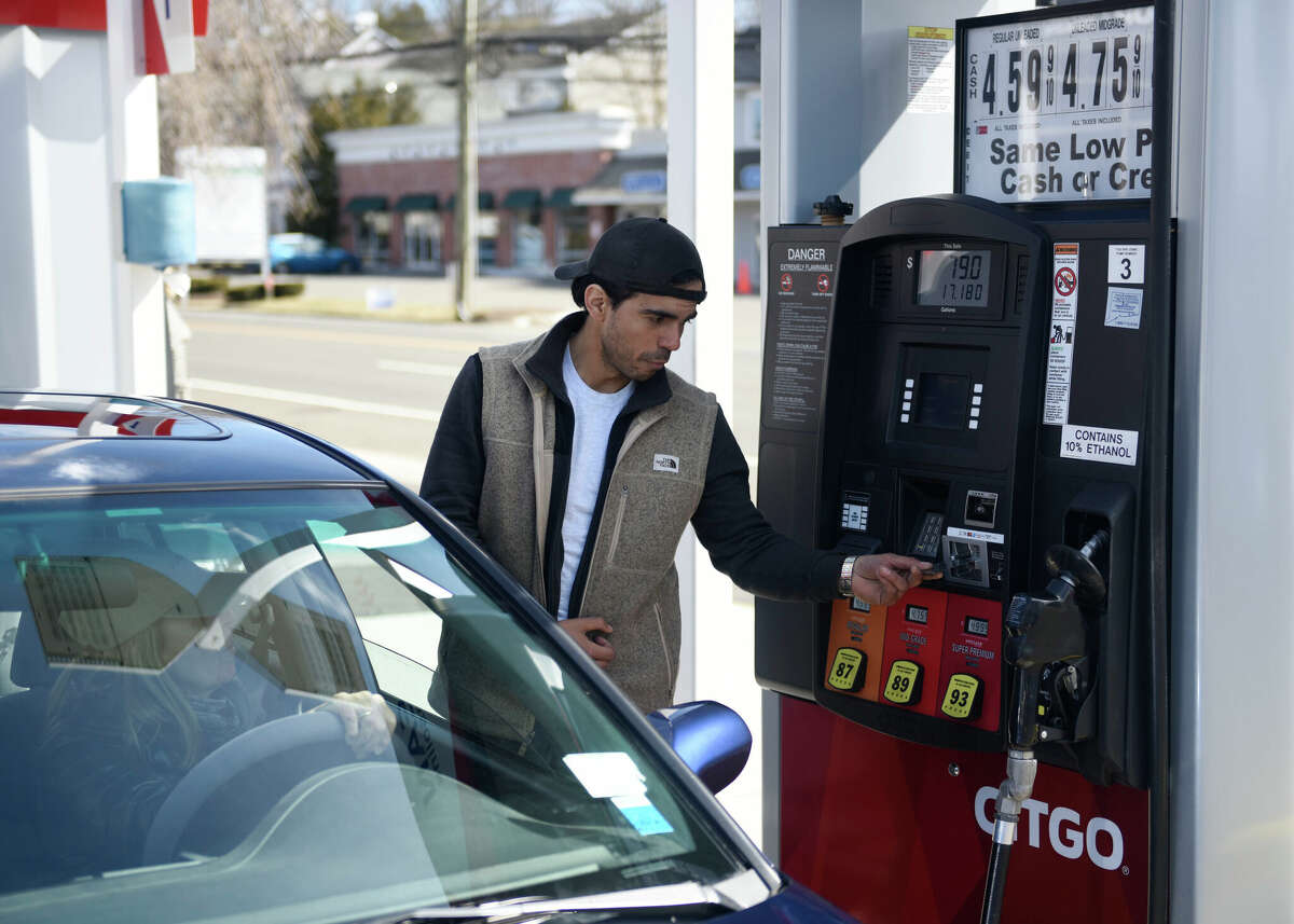 Rene Monges pumps gas for a customer at the Le Mans 24 Citgo in the Cos Cob section of Greenwich, Conn. Tuesday, March 8, 2022.