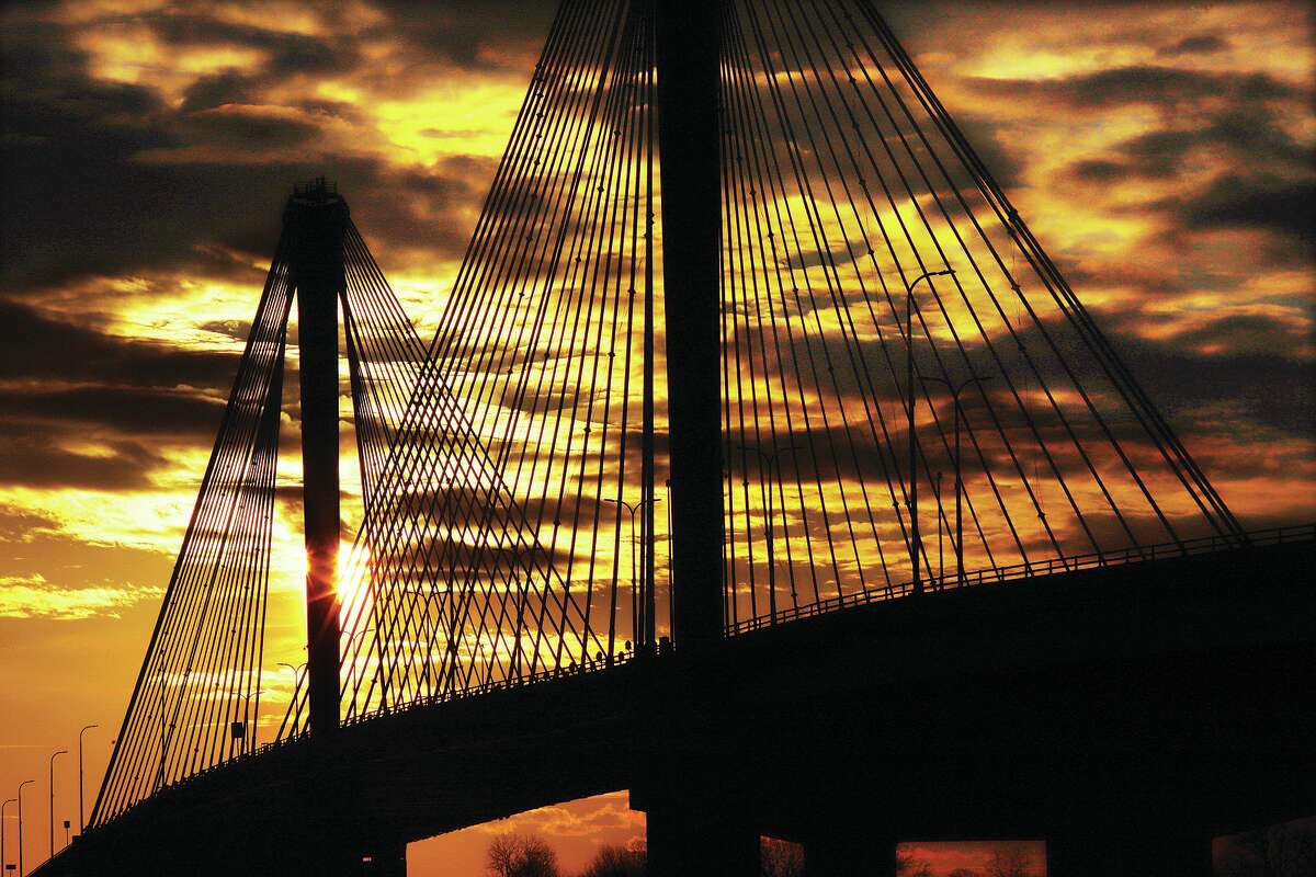 John Badman|The Telegraph A cold, winter-like sun sets behind the cables of the Clark Bridge in Alton Thursday night. Temperatures will remain cold and breezy through the weekend but are expected to climb back to a more seasonable high in the 50's for the coming week.