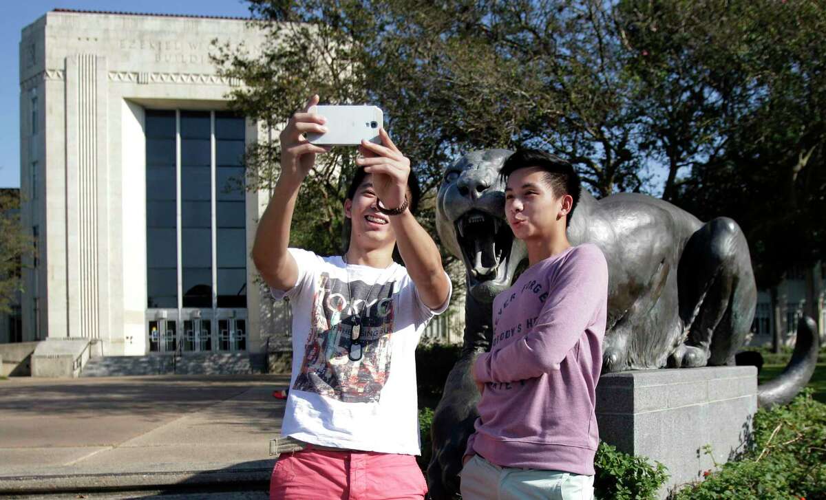 Perspective students Jeremy Sandil and Carlo Sandil take a moment to take a selfie with a bronze cougar during their University of Houston campus tour on Wednesday, Oct. 22, 2014, in Houston. ( Mayra Beltran / Houston Chronicle)